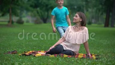 在公园里拥抱母亲的无忧无虑的男孩，单亲家庭社交节目